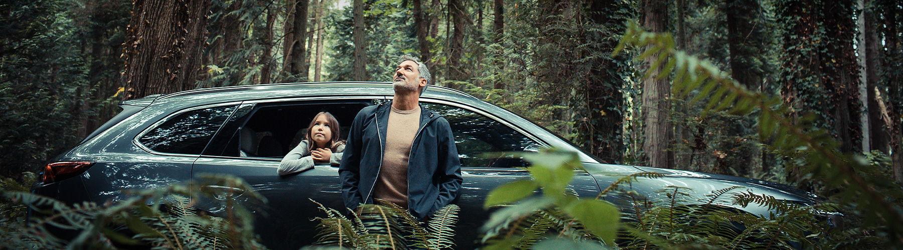 A dad and his daughter enjoying the forest with their Mazda CX-9