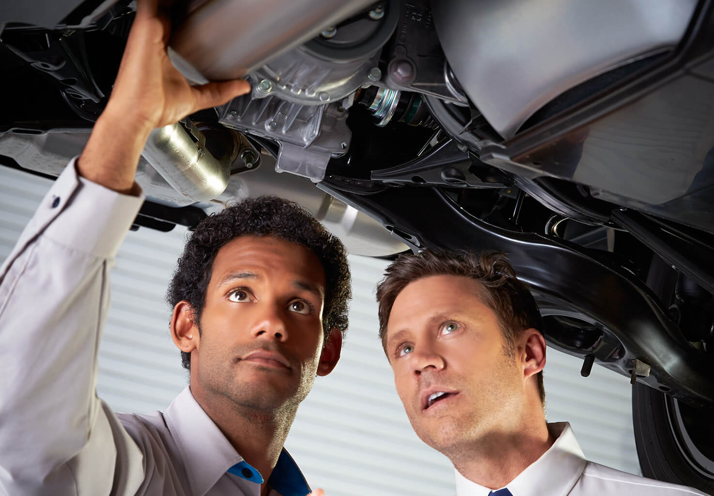 two men inspecting the workings of a car