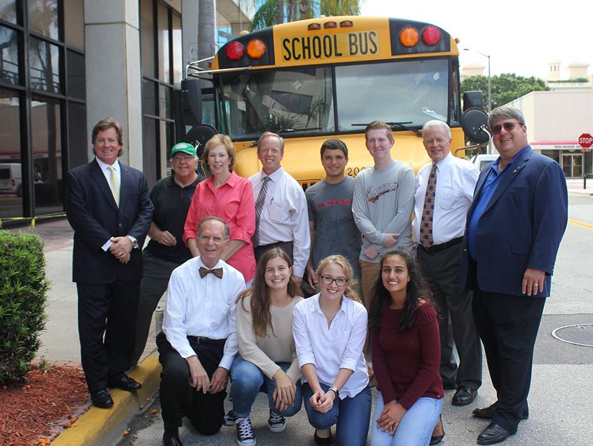 Photo of students and staff in front of school bus