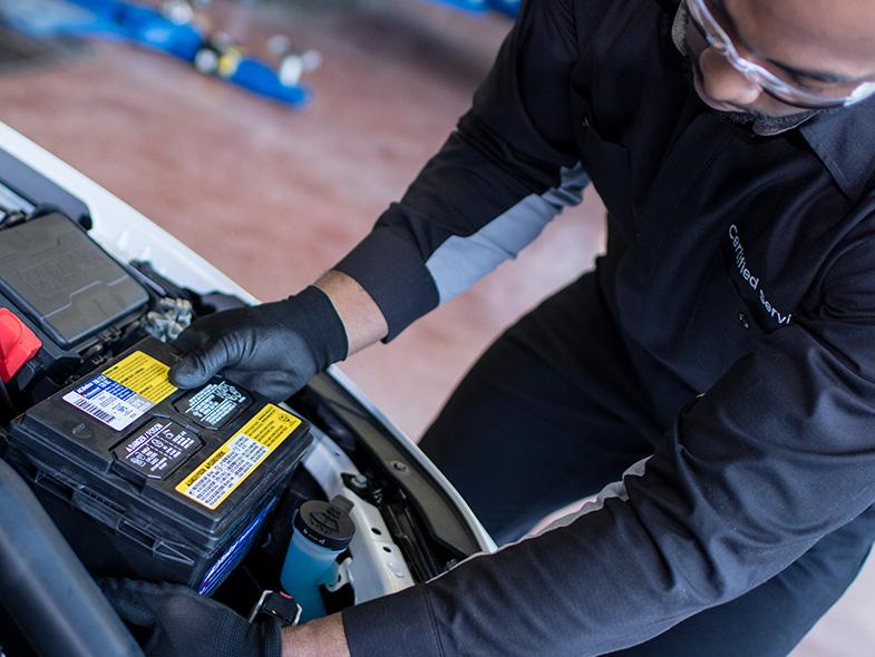 Service technician changing vehicle battery at our Chevy Truck Dealers Near Me Location