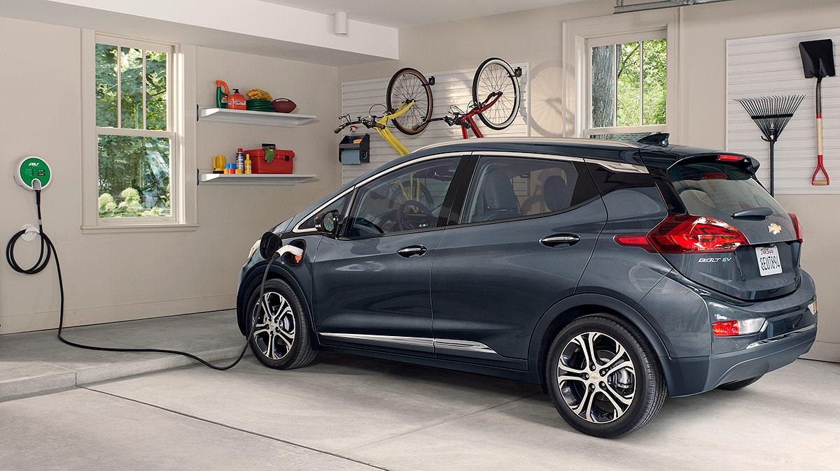 A grey Chevy Bolt EV charging charging in a garage.