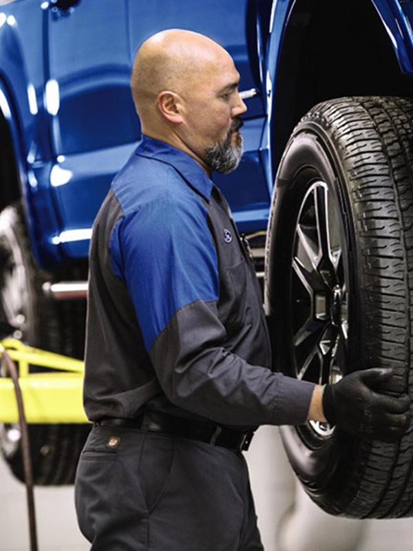 Ford Tire Tech putting tire on vehicle