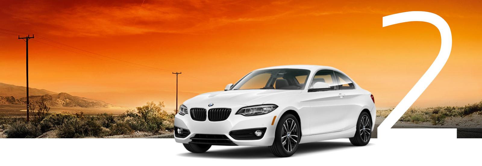 A white BMW 2 Series with a desert highway background.