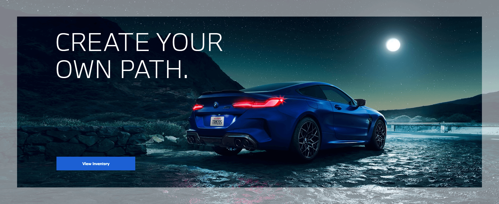 View Inventory. A BMW M8 parked by the side of a moonlit desert highway.