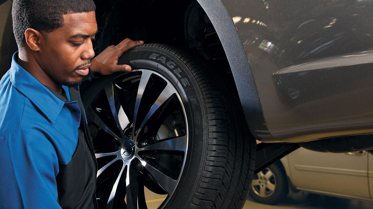 A mechanic changing the tires on a vehicle.