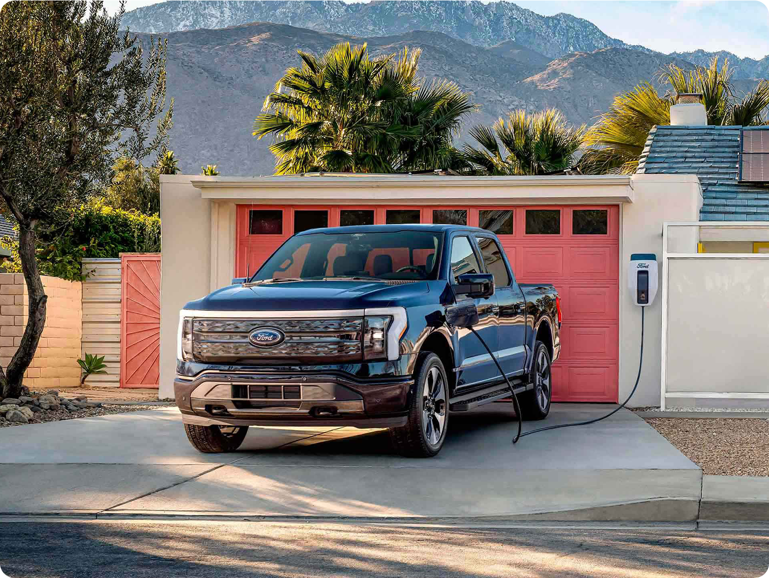 An F-150 Lightning charges in a driveway