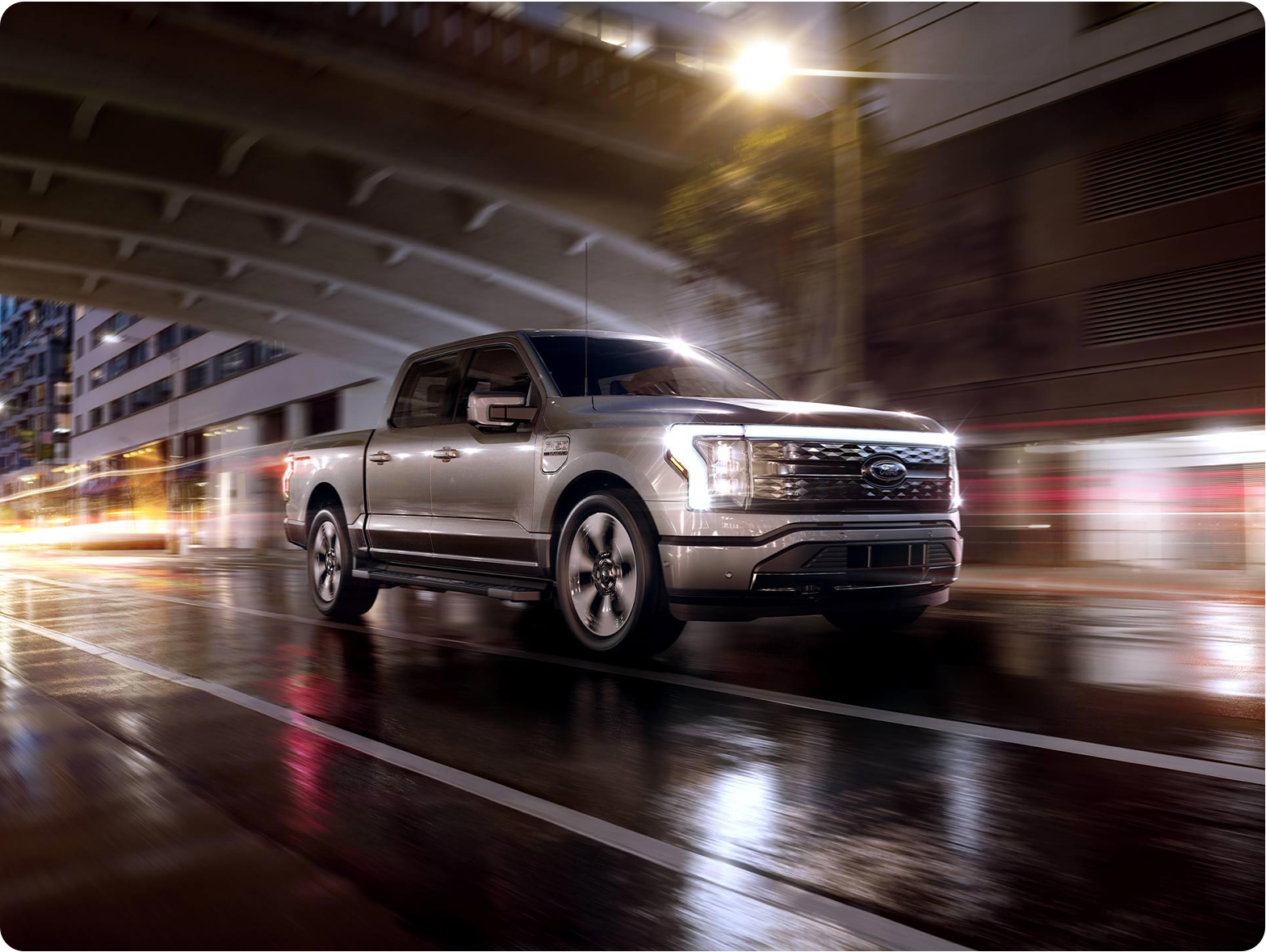 An F-150 Lightning® being driven in the city at night