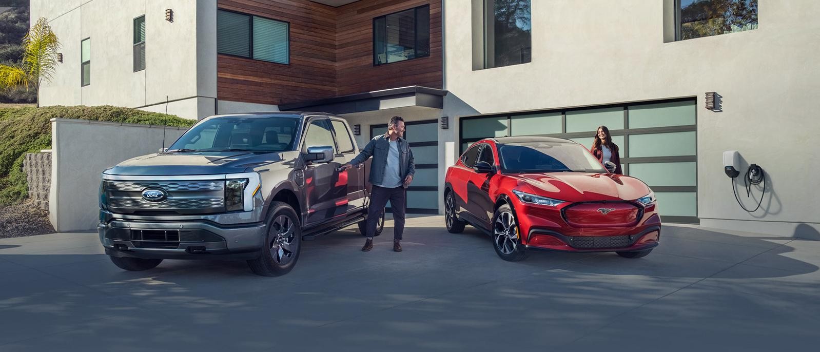 A man steps into an F-150 Lightning® truck as a woman steps into a Mustang Mach-E® SUV