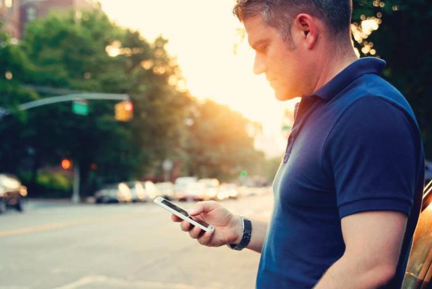 Man looking at his phone on a sunny day.