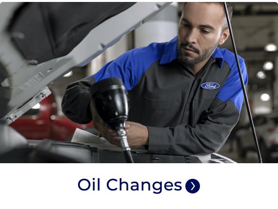 Service technician changing car oil