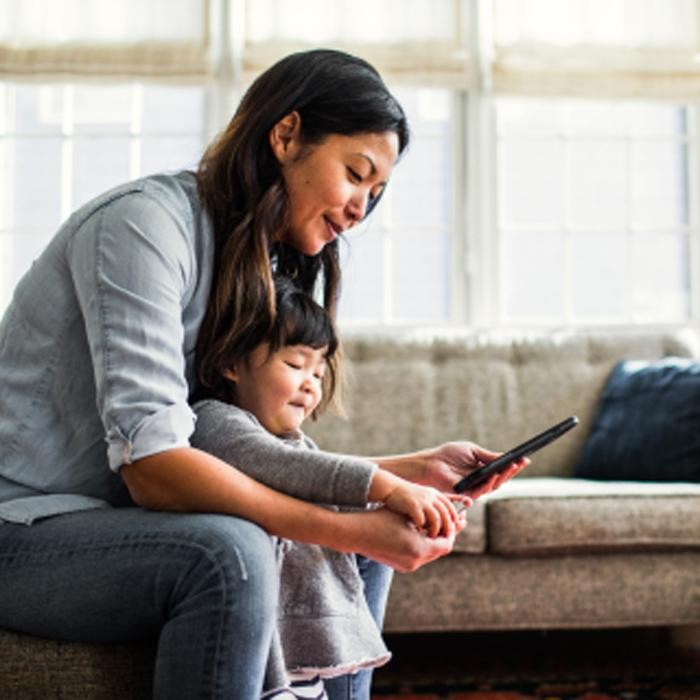 A woman and child looking at a cell phone.