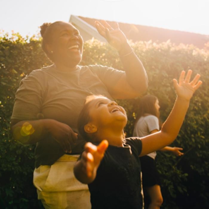 A woman and child laughing outside. 