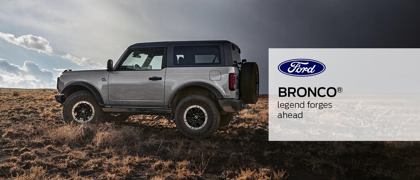 Grey 2023 Ford Bronco is sprinting on mountain road.