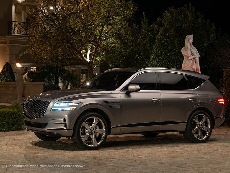 A Silver 2021 Genesis GV80 parked in front of a mansion..