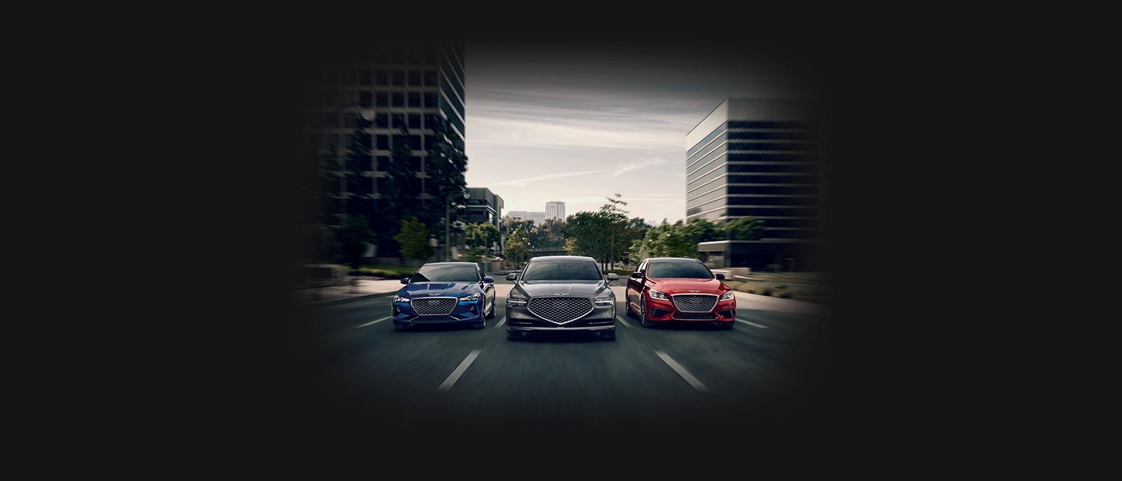 Head-on view of three Genesis models driving down a city street.