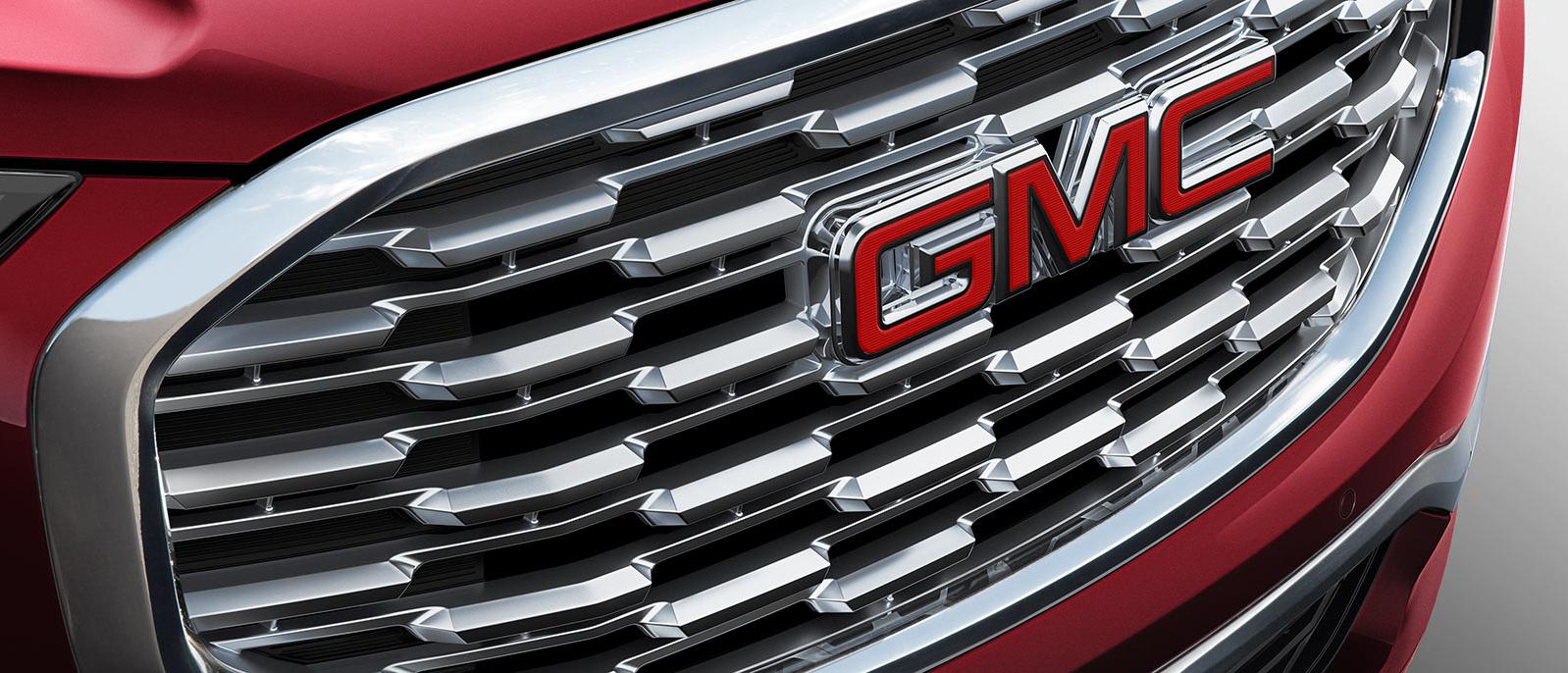 Close up of a GMC Denali Grille featuring the logo.