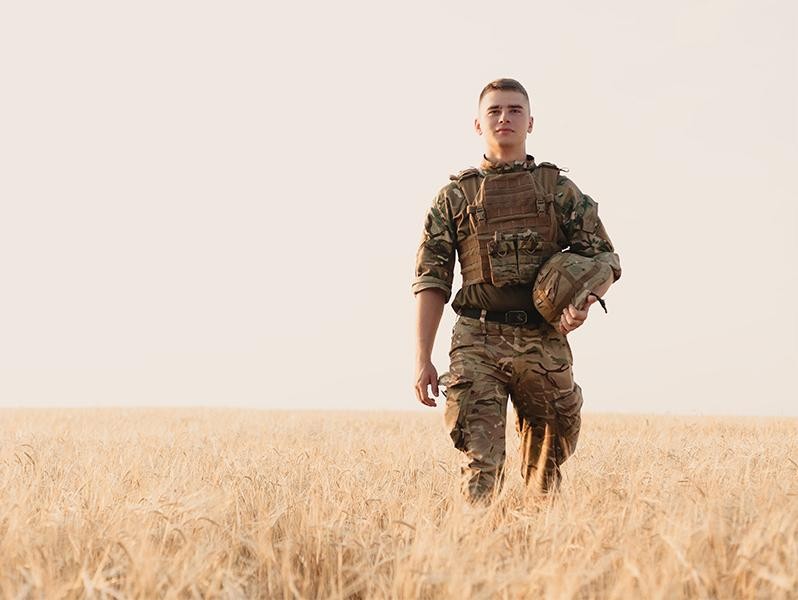 Soldier standing against field 