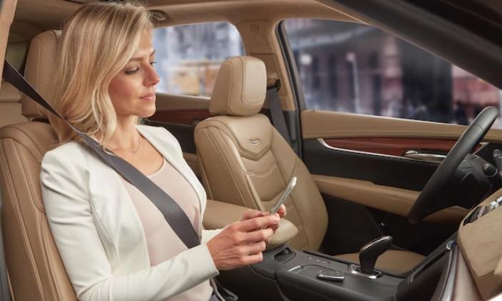 Woman looking at her phone in a Cadillac