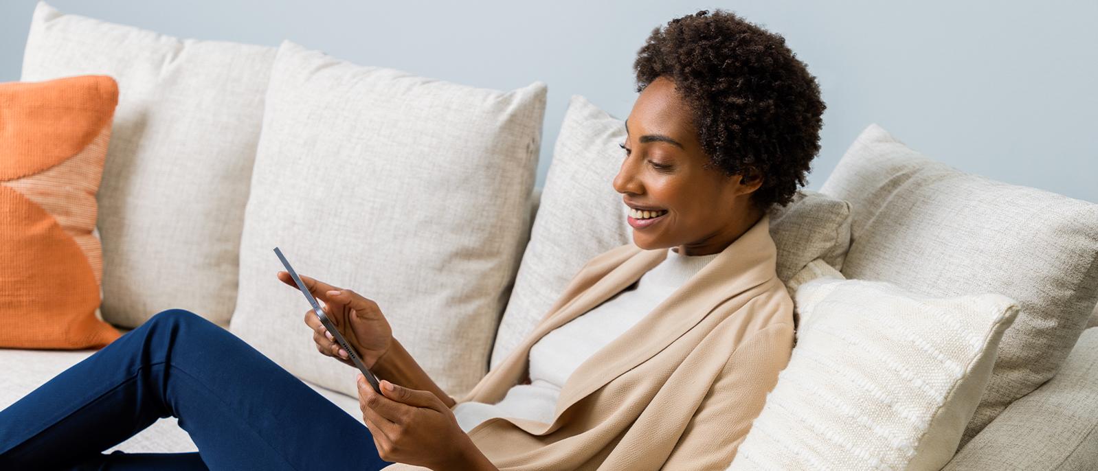 Woman on couch shopping on a tablet