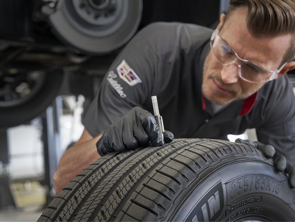 Cadillac Protection Expert Checking Tire