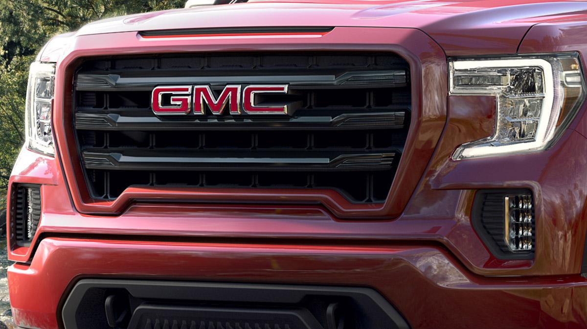 New GMC Vehicles - Close-up a red Sierra 1500 front grille.