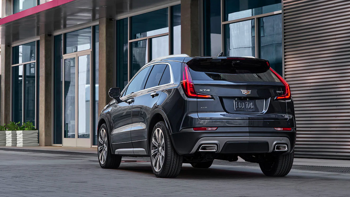 Rear view of a grey Cadillac XT4 parked on a city street.