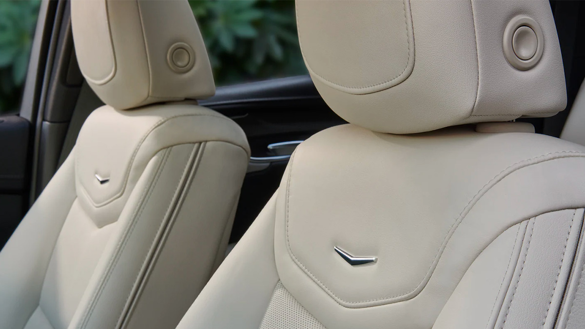 Interior detail view of the front seats of a Cadillac XT5 finished in cream-colored leather.
