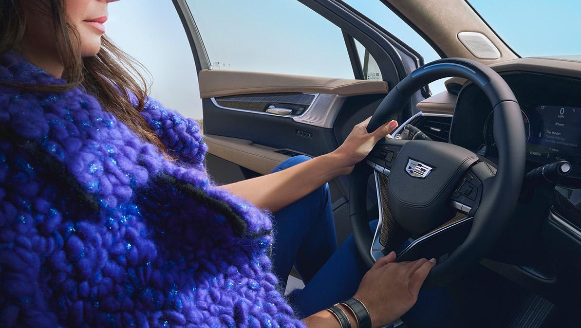 A Woman Uses Both Hands to Hold the Steering Wheel of the Cadillac XT6