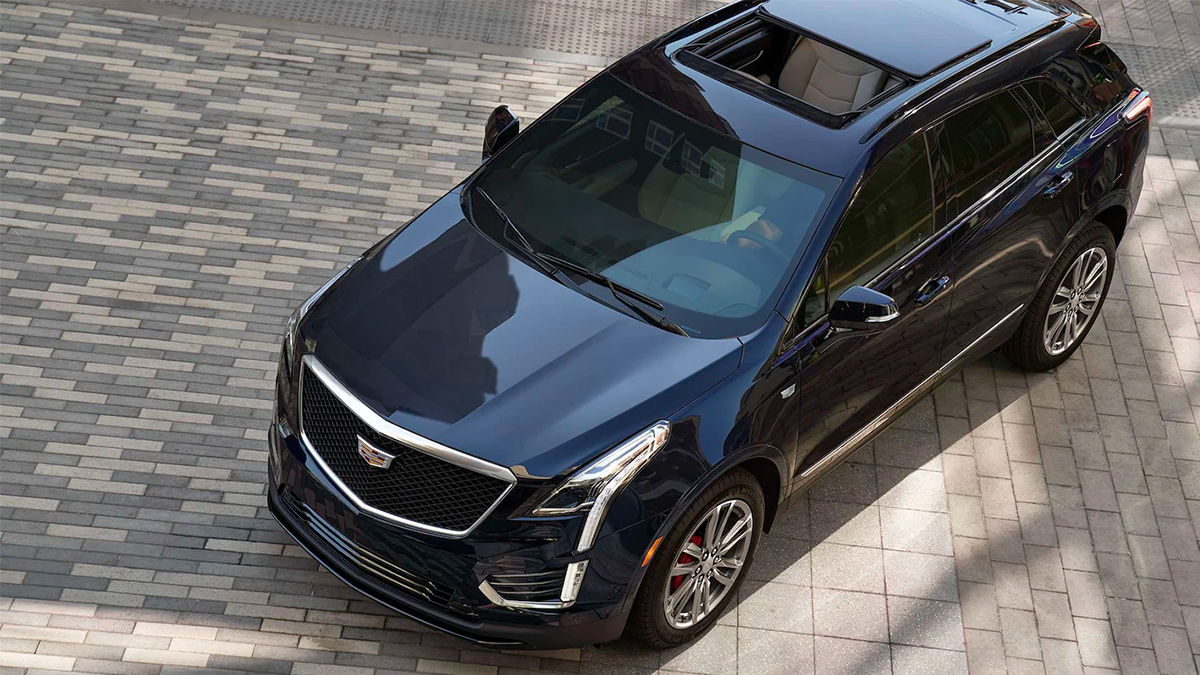 Overhead view of a black Cadillac XT5 on a brick courtyard.
