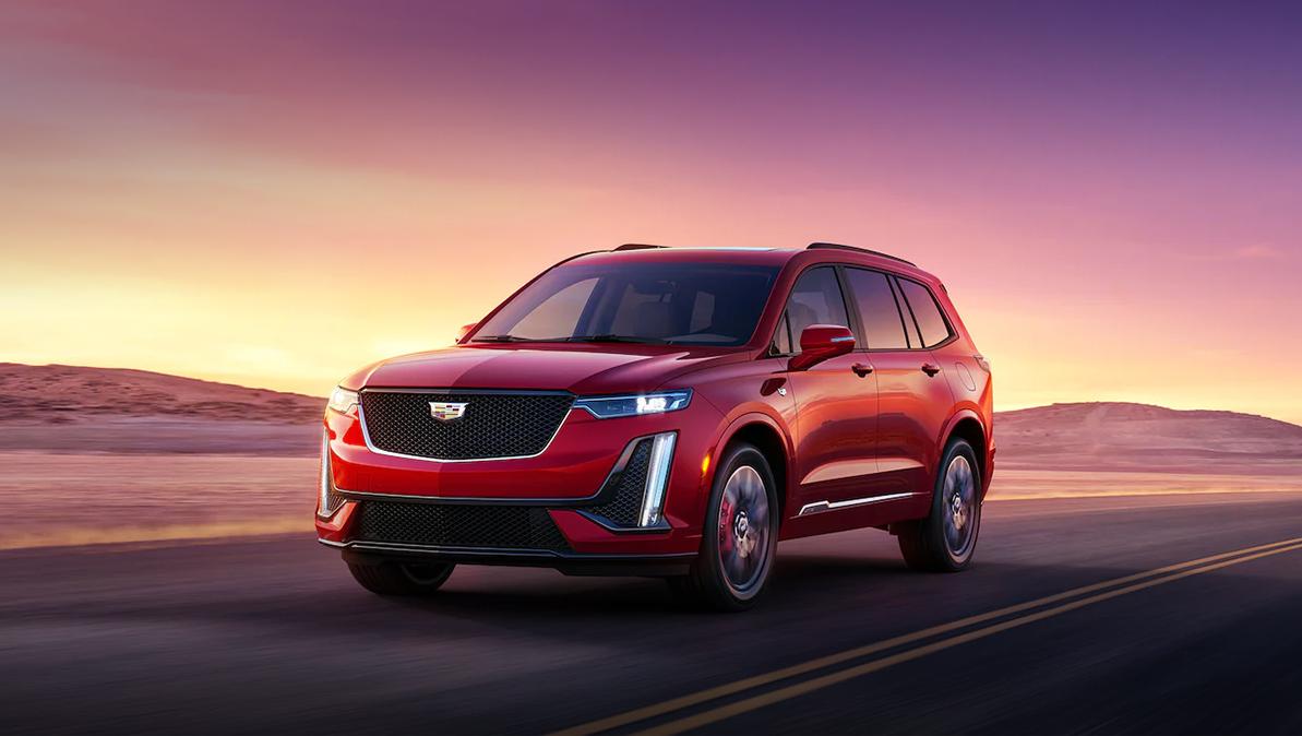 A red 2023 Cadillac XT6 driving on the road.