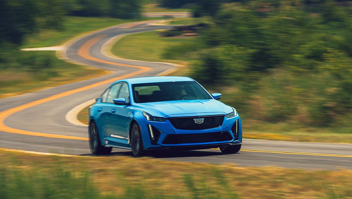 A blue Cadillac CT5-V driving along a curvy country road.