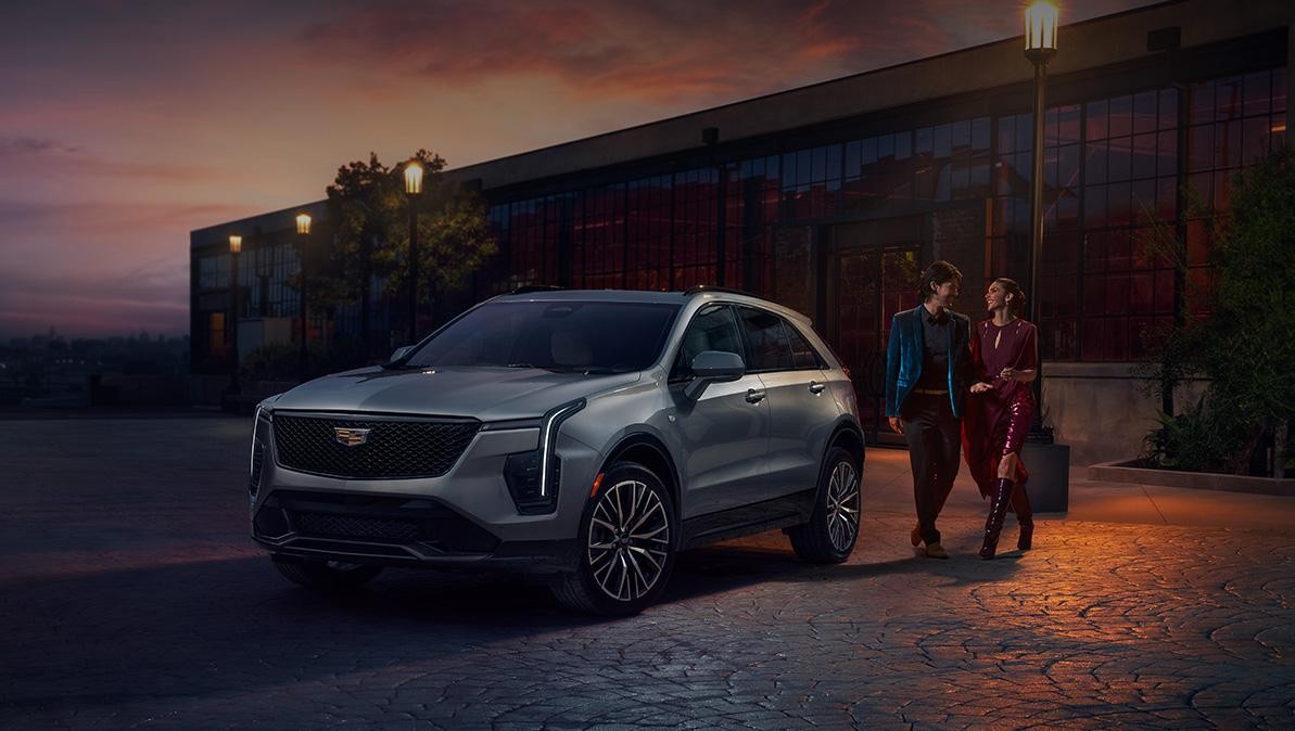 A Couple Share a Laugh as they Approach Their Cadillac XT4 During a Beautiful Sunset