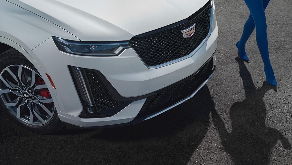 A Person Walks Along Side of a Parked Cadillac XT6.