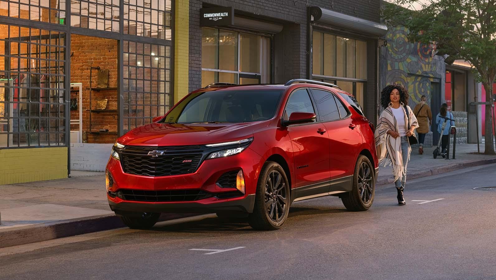 A girl walking near Red Chevrolet Equinox