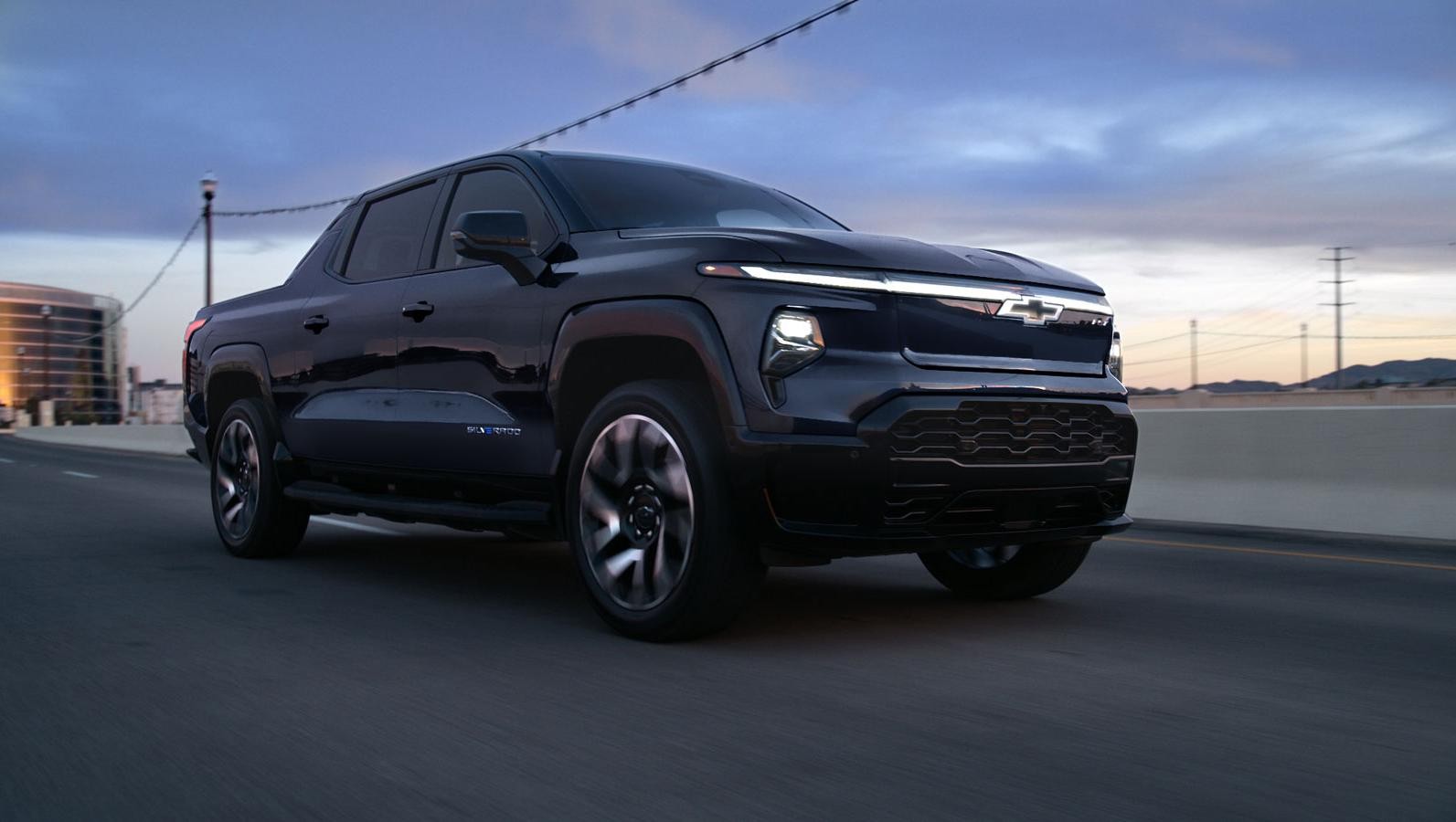 Black 2024 Chevrolet Silverado EV driving in a city