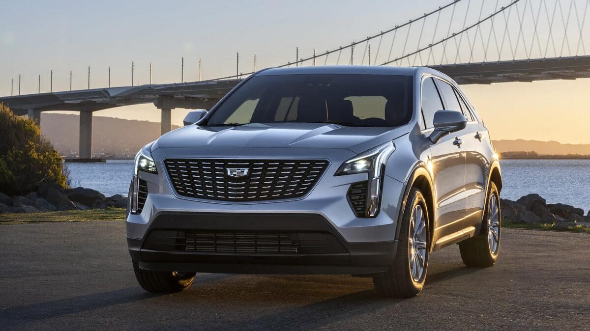 Front shot of gray XT4 in front of bridge at sunset