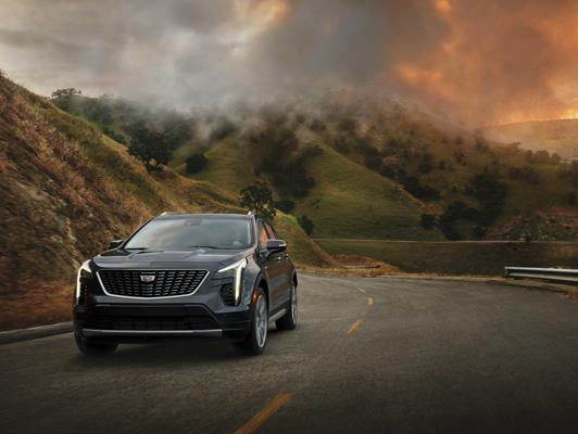 Cadillac driving away from fires in mountains