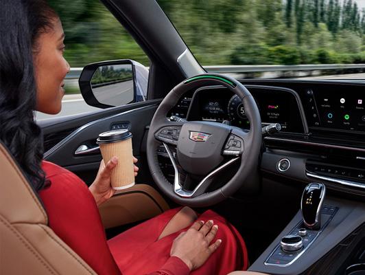 Woman holding coffee and not using the steering wheel