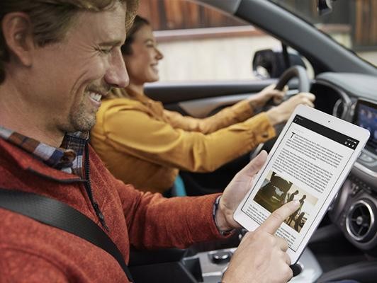 Man with tablet and woman driving