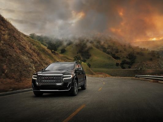 Black GMC driving away from fire in mountains