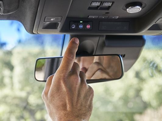 Man pushing onstar button on cadillac