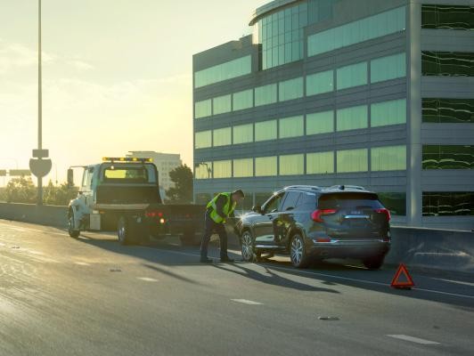 GMC being picked up by tow truck in city