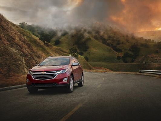 Red Equinox driving away from fire in mountains