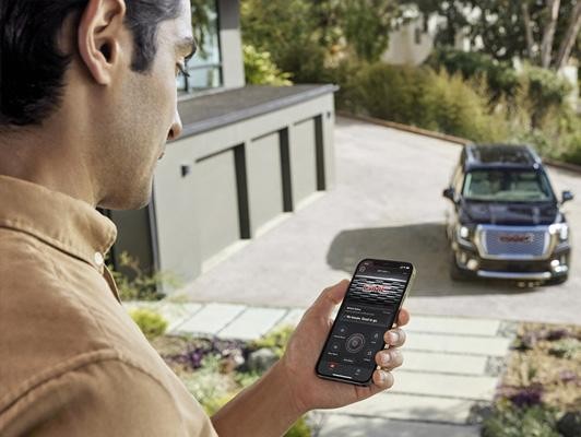 man on phone app looking at GMC vehicle