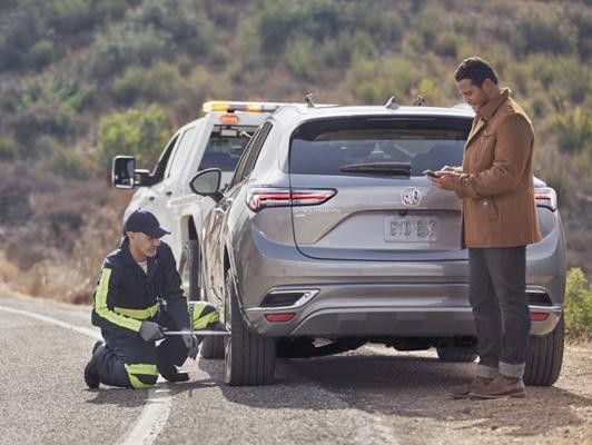 Someone fixing Buick tire on side of road