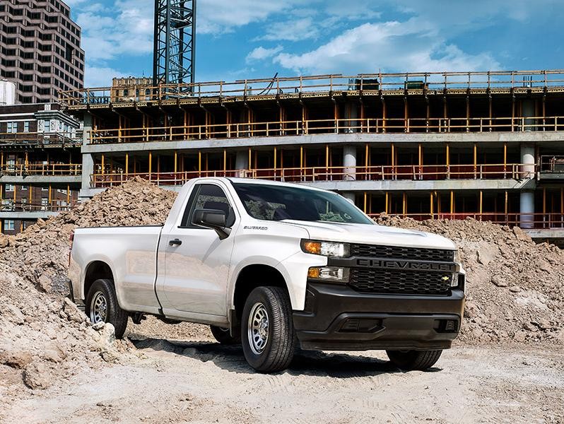 A white Chevrolet Silverado 1500 Work Truck at a construction site.