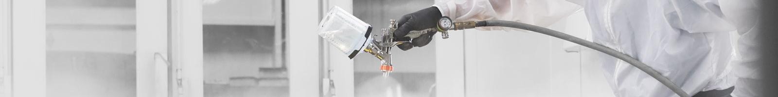 Man painting car in a paint booth