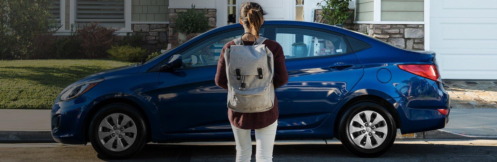 College Girl standing in front of blue hyundai
