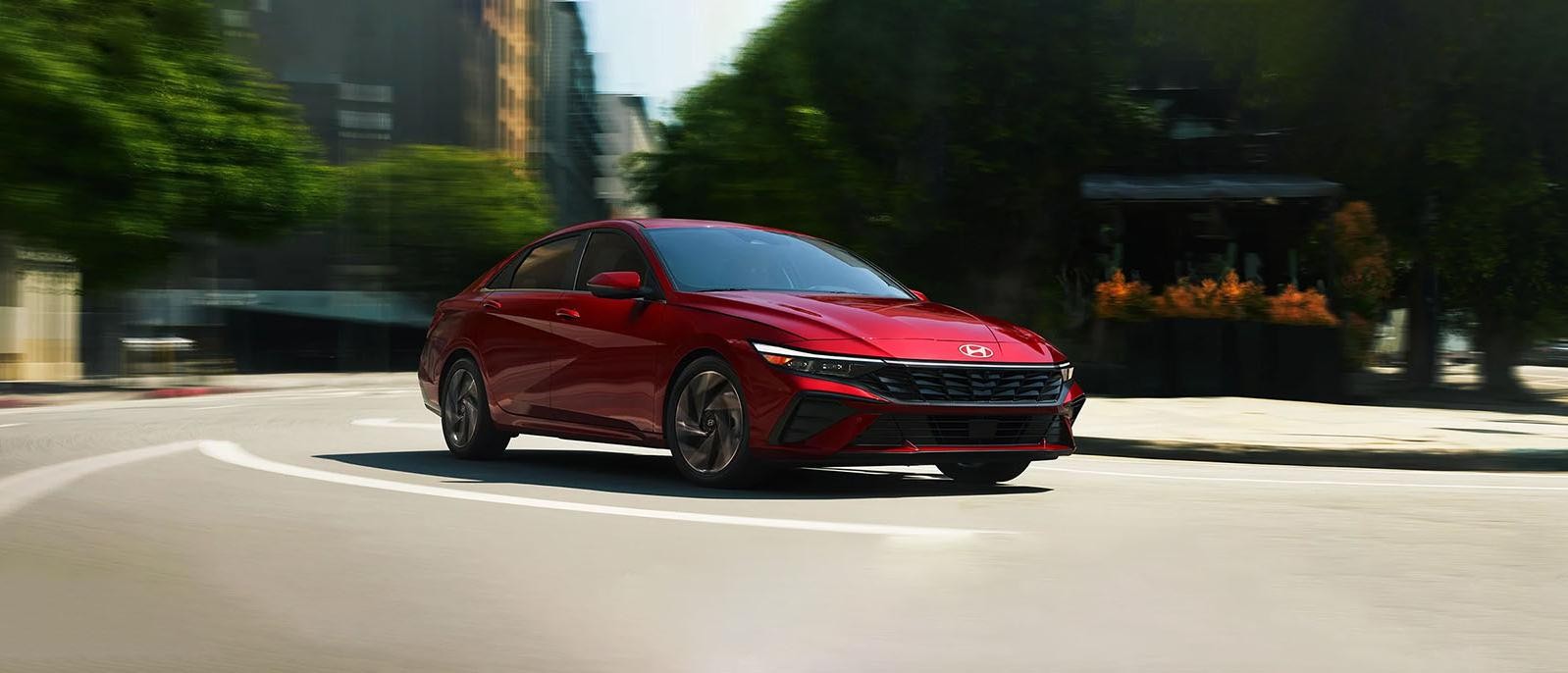 A red Hyundai Elantra driving on road.