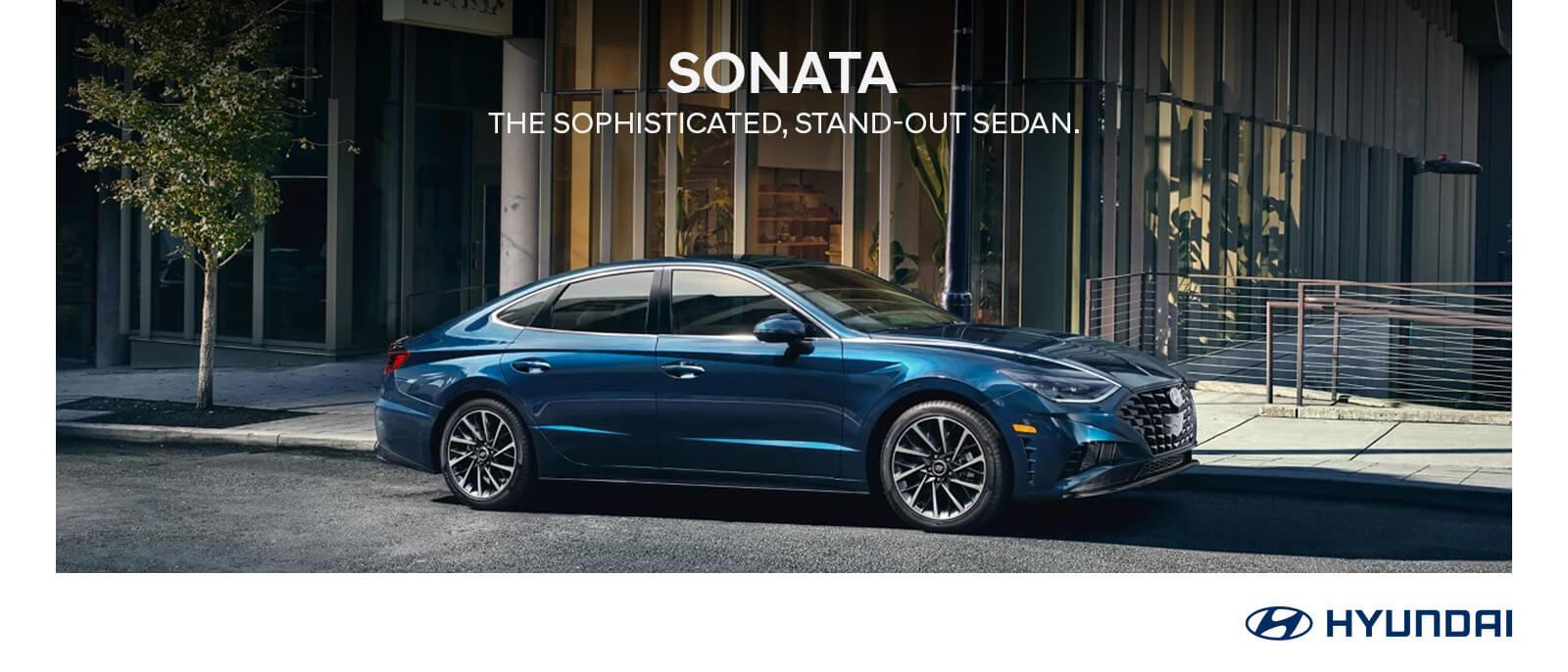 2023 Blue Hyundai Sonata with tree and building in background.